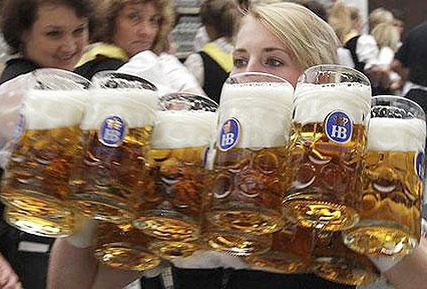 1. Nữ nhân viên bưng hàng loạt vại bia phục vụ khách sau mở màn lễ hội Oktoberfest. Ảnh: Reuters.