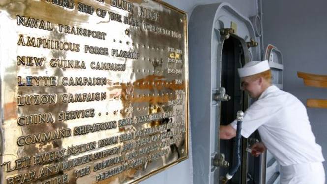A US Navy sailor enters the deck of the USS Blue Ridge next to a plaque which lists the ship's involvement in several service campaigns, during a media tour on board the ship at Westport near Port Klang, 06 March 2006.